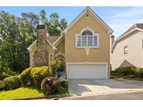 Charming home with a stone chimney, manicured landscaping and an attached two-car garage at 1902 Connemara Dr, Atlanta, GA 30341