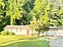 Quaint one-story home with a well-maintained lawn and mature trees for shade and curb appeal at 4363 Stonewall Tell Rd, Atlanta, GA 30349