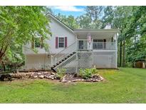Charming home with a inviting front porch, set amidst lush greenery and a landscaped yard at 1341 Little Deer Run, Canton, GA 30114