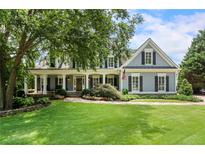 Charming two-story home with a welcoming front porch, lush lawn, and mature landscaping at 2429 Kirk Nw Ln, Kennesaw, GA 30152