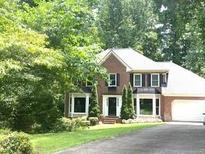 Charming two-story brick home with a manicured lawn and lush green landscaping at 2402 Woodbridge Dr, Marietta, GA 30066