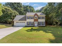 Charming two-story home with blue shutters, well-manicured lawn, and attached two car garage at 2505 Hamilton Parc Ln, Buford, GA 30519