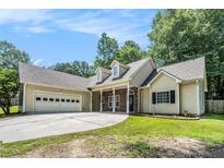 Charming single-story home featuring a stone-accented entrance and a spacious two-car garage at 114 Arborwood Way, Temple, GA 30179
