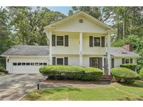 Inviting two-story home featuring a two-car garage, manicured landscaping and a charming front entrance at 1651 King Rd, Riverdale, GA 30296