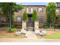 Charming brick townhome featuring a landscaped yard and wrought iron fence at 1618 Durden Ne Rd, Atlanta, GA 30319