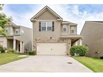Charming two-story home featuring stone accents, a two-car garage, and a well-maintained front yard at 529 Dasheill Ln, Atlanta, GA 30349