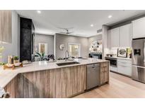 Open kitchen features a large island with quartz countertops, stainless steel appliances, and hardwood floors at 1099 North Ne Ave # 12, Atlanta, GA 30307