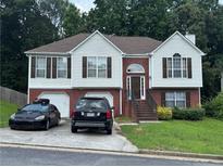Charming two-story home with a brick and white exterior, a two-car garage, and a well-maintained front yard at 4192 Rhinehart Dr, Austell, GA 30106