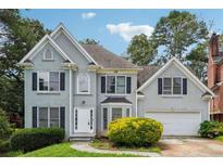 Charming two-story home with a well-manicured lawn, lush greenery, and attached garage at 4467 Boatmans Cv, Stone Mountain, GA 30083