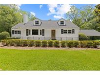 Charming home featuring a white exterior, landscaped yard, and a covered parking area at 357 W Hightower Trl, Social Circle, GA 30025