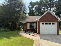 Charming brick home featuring a one-car garage and a well-manicured lawn at 8113 Fieldstream Way, Douglasville, GA 30134