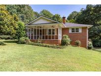 Charming brick home with a screened-in porch and mature landscaping at 5670 Lanny Dr, Powder Springs, GA 30127