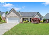 Charming single-story home featuring a well-manicured lawn and a welcoming front porch with a two-car garage at 609 Grand Ashbury Ln, Sugar Hill, GA 30518