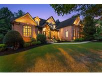 Charming brick home featuring a manicured lawn and inviting entrance enhanced by elegant stonework at 5507 Aviemore Ct, Suwanee, GA 30024