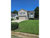 Charming two-story home features a manicured lawn, attached two-car garage and mature trees at 4209 Resheemah St, Atlanta, GA 30349