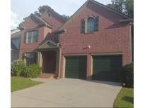 Beautiful two story brick home featuring a two-car garage, manicured landscaping, and classic architectural details at 727 Pear Grove Pl, Marietta, GA 30066