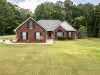 Charming brick home features a well-manicured lawn, dark shutters, and a lovely landscape perfect for suburban living at 15 Fairwoods Ct, Covington, GA 30016