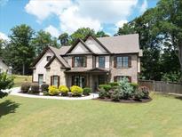 Charming two-story home with brick and siding, complemented by a well-manicured lawn and beautiful landscaping at 538 Mulberry Fern Dr, Auburn, GA 30011