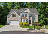 Charming brick home with a well-manicured front yard and mature trees at 1343 Cartwright Ln, Lawrenceville, GA 30045