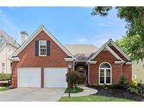 Charming brick home with a two-car garage and well-manicured front yard under a clear blue sky at 1805 Wilkenson Xing, Marietta, GA 30066