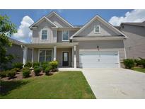 Charming two-story home with a manicured lawn, a two-car garage and covered front porch at 2504 Bear Mountain St, Lithonia, GA 30058