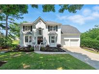 Charming white two-story home with a well-manicured lawn and attached two car garage at 312 Laurel Run Cv, Sugar Hill, GA 30518