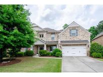 Two-story brick home featuring an attached two-car garage and a well-manicured front lawn at 2535 Castlerock Ct, Cumming, GA 30041
