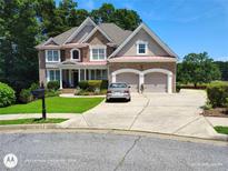 Beautiful two-story home with manicured lawn, two-car garage, and brick and stucco exterior at 1292 Hidden Spirit Trl, Lawrenceville, GA 30045
