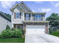 Charming two-story home with a stone-accented facade, well-manicured lawn, and a two-car garage at 212 Torch Dr, Acworth, GA 30102