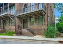 Beautiful brick townhouse featuring a charming covered entrance and elegant iron railings at 504 E Howard Ave, Decatur, GA 30030