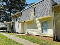 Exterior view of a two-story home with neutral siding, gray roof, tidy landscaping, and a sidewalk leading to the front door at 4383 Idlewood Ln, Tucker, GA 30084