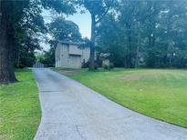 Inviting two-story home with a spacious front yard and a long driveway surrounded by mature trees at 4007 Stacy Ln, Snellville, GA 30039