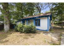 Charming home with light siding, blue trim, and a cozy front yard with mature trees and bushes at 1321 Mcclelland Ave, Atlanta, GA 30344