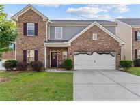 Charming two-story brick home with a well-manicured lawn and an attached two-car garage at 1742 Weatherbrook Cir, Lawrenceville, GA 30043