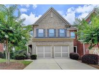 Charming two-story brick home with a two-car garage and a beautifully landscaped front yard at 4165 Hammond Bridge Dr, Suwanee, GA 30024