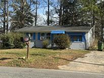 Charming single-story home featuring a brick facade, blue trim, and a well-maintained lawn at 685 Bolton Nw Rd, Atlanta, GA 30331