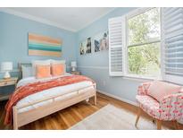 Bright bedroom with light blue walls, wood floors, and a large window letting in natural light at 200 B Reinhardt Se St, Atlanta, GA 30312