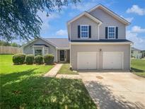 Charming two-story home with a two car garage, manicured lawn and mature landscaping at 2226 Exchange Se Pl, Conyers, GA 30013