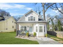 Charming two-story home featuring a cozy front porch, a well-manicured lawn, and a welcoming entrance at 1995 Meador Ave, Atlanta, GA 30315