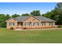 Charming brick home featuring a well-manicured lawn and green shutters at 604 Clearwater Ct, Mcdonough, GA 30252