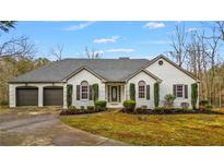 Charming single-story home featuring a two-car garage, manicured lawn, and classic architectural details at 8160 Stone Hill Rd, Cumming, GA 30028