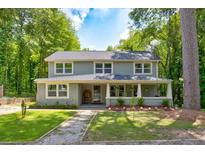 Charming two-story home with a welcoming front porch and landscaped yard at 174 Rivertown Rd, Fairburn, GA 30213