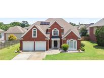 Charming two-story brick home features a well-manicured lawn and two-car garage at 3735 Turnbury Oaks Dr, Peachtree Corners, GA 30096