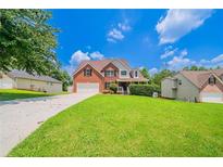Charming brick home featuring a well-maintained lawn and a spacious driveway leading to a two-car garage at 3961 S River Ln, Ellenwood, GA 30294