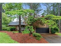 Charming home featuring wood siding, well-manicured landscaping, and an attached two-car garage at 490 Hunters Glen Ct, Lawrenceville, GA 30044