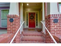Inviting front entrance with brick steps, white rails, and vibrant red door adorned with wreath at 2107 Se Gorman Se Grv # 132, Atlanta, GA 30316