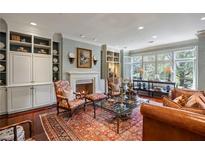 Elegant living room with fireplace, custom built-ins, and large windows providing natural light at 1 Brookhaven Ne Dr # 205, Atlanta, GA 30319