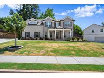 Beautiful two-story home boasts a well-manicured lawn and brick and siding exterior with stately front columns at 1620 Brook Ivy Dr, Lawrenceville, GA 30044