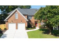 Charming two-story brick home with a well-manicured lawn, two-car garage, and lovely landscaping at 1560 Oak Park Cv, Decatur, GA 30033