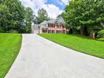 Beautiful two-story home with a long driveway and well-maintained lawn and mature trees at 4221 Bretdale Nw Run, Kennesaw, GA 30152